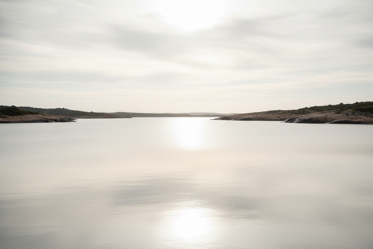 Cinematic photorealistic image of soft sunlight reflecting across calm water, forming a bright line between two shores. Neutral beige and silver tones, smooth gradients, high-end editorial mood, representing unity and responsible engagement.